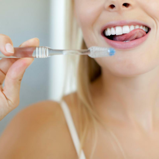 image of woman brushing her teeth showing maintenance of teeth whitening